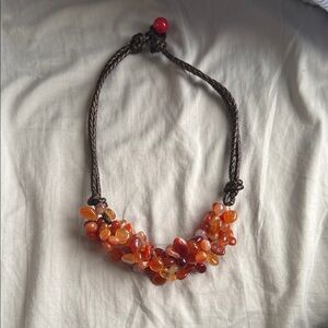 cluster of polished carnelian or agate gemstone beads on knotted string